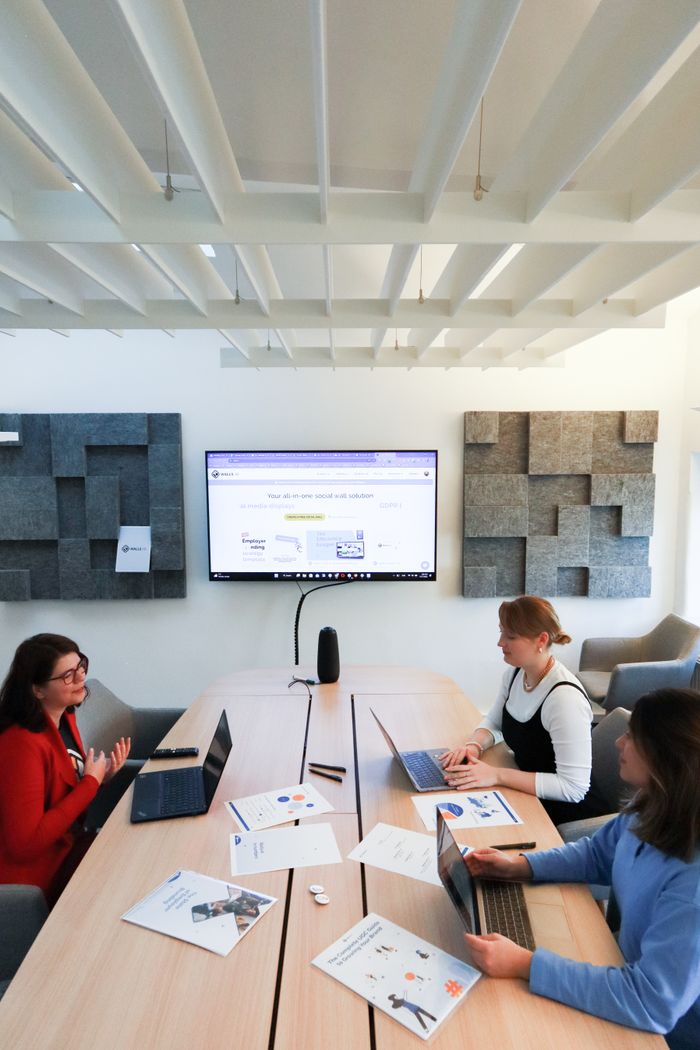 digital Women collaborating in a modern office, engaging in teamwork and technology discussions.