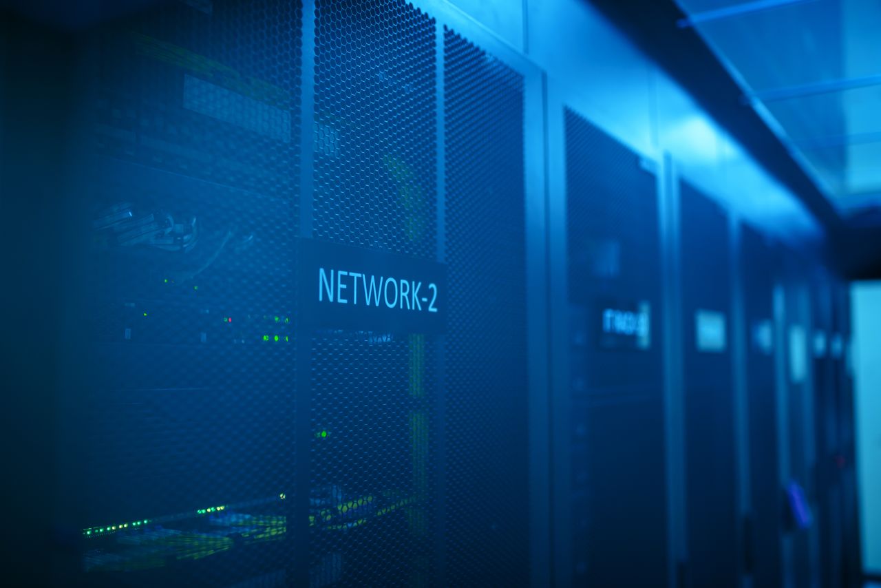 Services-03 A modern server room featuring network equipment with blue illumination. Ideal for technology themes.